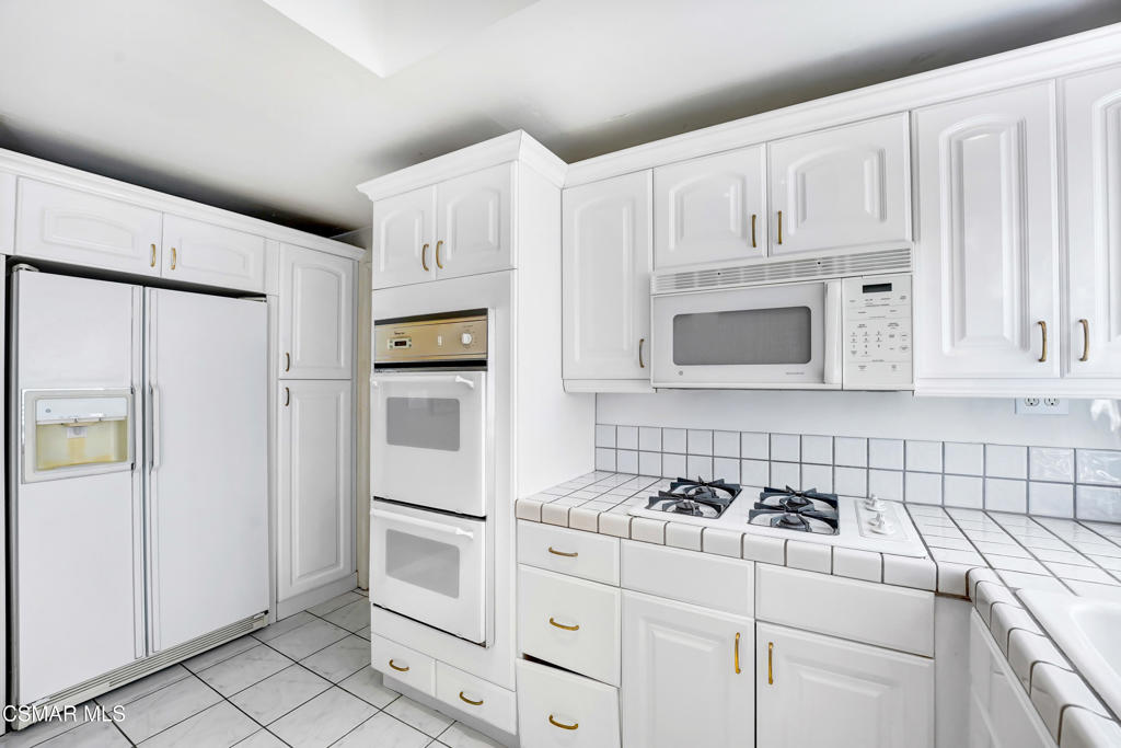 2872 Galena Avenue Simi Valley, CA 93065 - Photo 5 of 20 a kitchen with white cabinets and white appliances