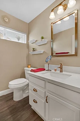 a bathroom with a toilet sink vanity and mirror