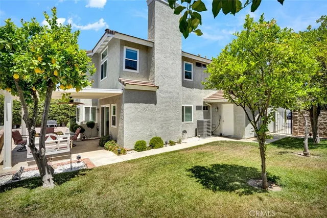 a view of a house with backyard and sitting area