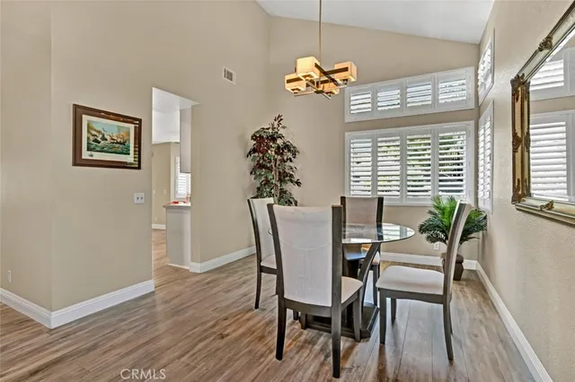 a dining room with furniture a chandelier and wooden floor