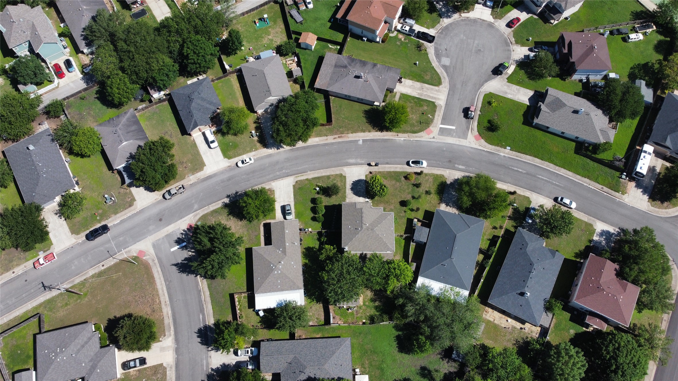338 Spring Branch Loop Kyle, TX 78640 - Photo 33 of 36 An aerial perspective showcases a vibrant suburban neighborhood with manicured lawns and curving streets.