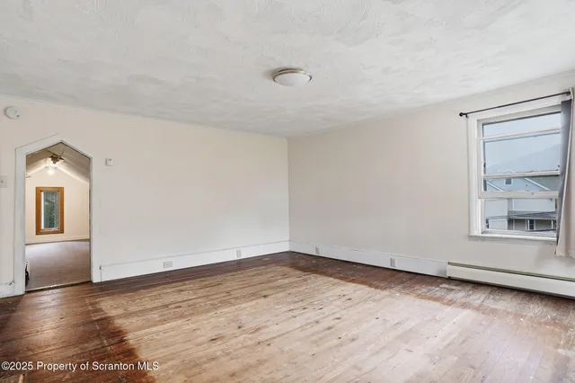 wooden floor in an empty room with a window