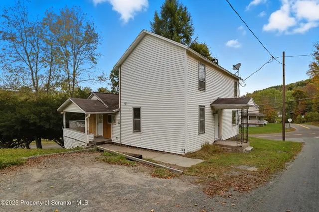 a front view of house with yard and trees in the background