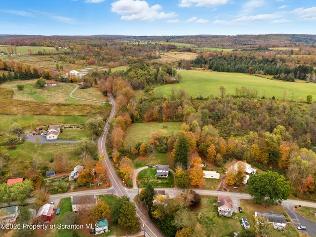 an aerial view of residential houses with outdoor space and trees