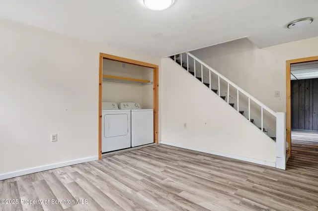 a view of a hallway with wooden floor and entryway