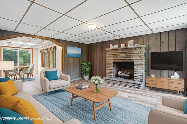 a living room with furniture a flat screen tv and a fireplace