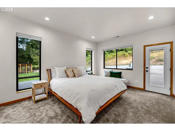 a living room with a bed furniture and a large window