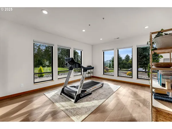 a living room with a large window wooden floor and furniture