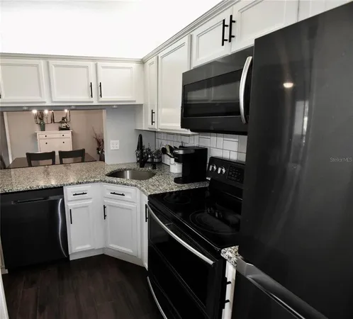 a kitchen with stainless steel appliances granite countertop a sink and cabinets
