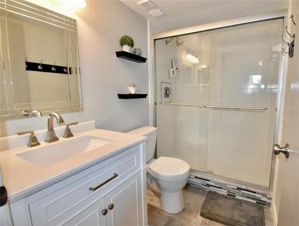 a bathroom with a sink a toilet a mirror and shower