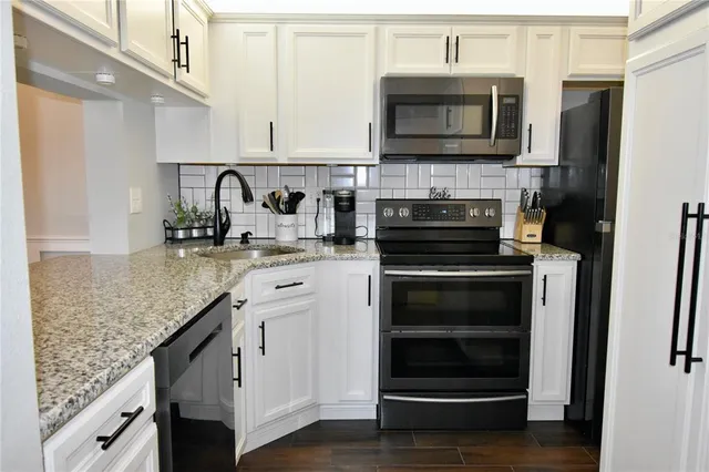 a kitchen with granite countertop a stove microwave and oven
