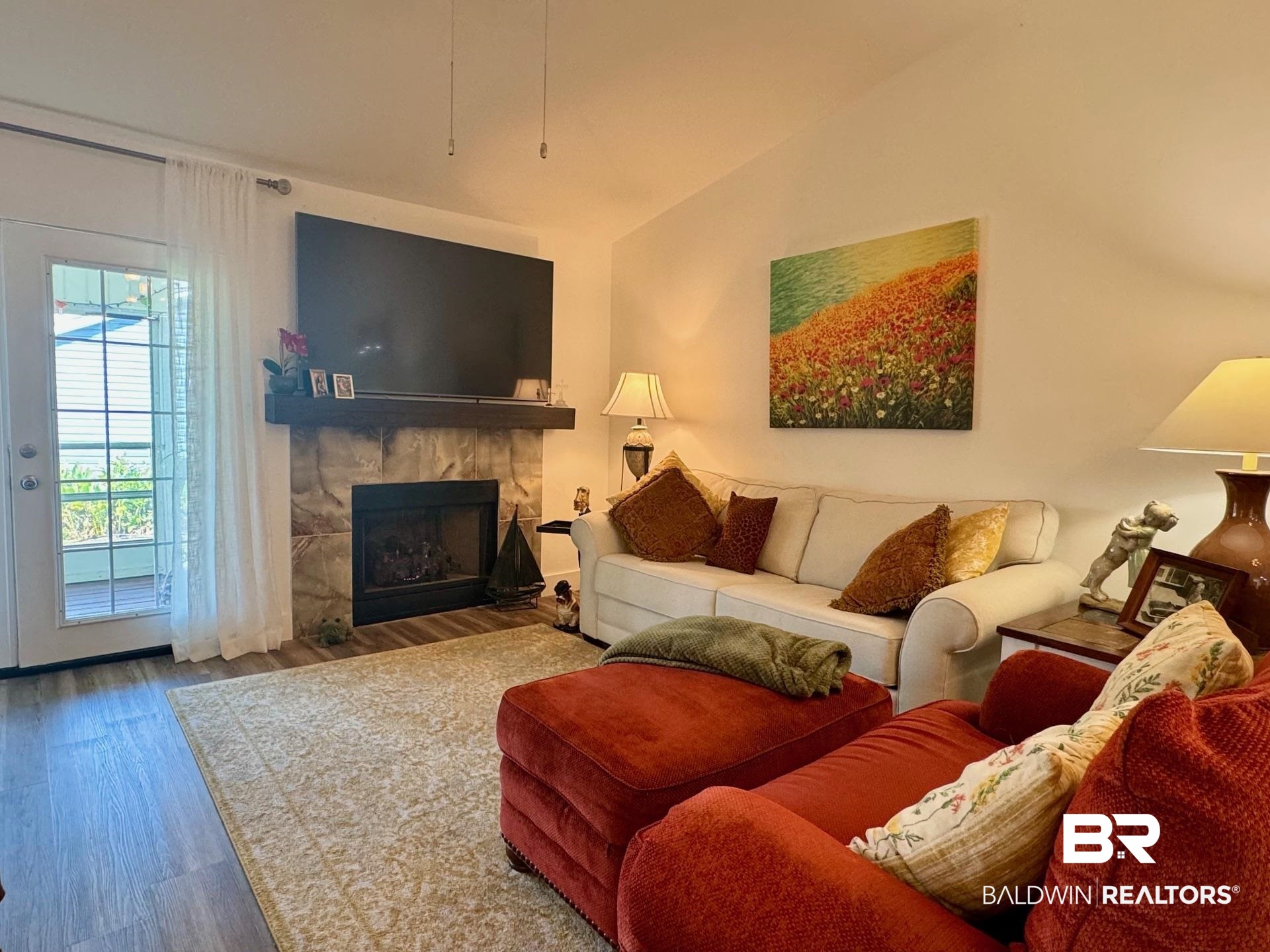 3200 Loop Road, Unit 55 Orange Beach, AL 36561 - Photo 2 of 40 Living room with lofted ceiling, hardwood / wood-style floors, and a tiled fireplace