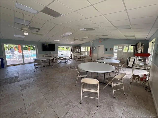 a outdoor space with lots of tables a computer on the table and chairs