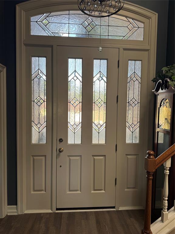 1762 Timber Ridge Circle Corinth, TX 76210 - Photo 3 of 26 Entryway featuring an arched transom with decorative glass, sidelight windows, and wood-finish flooring