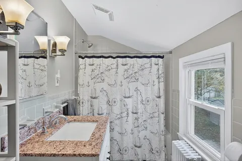 a bathroom with a granite countertop shower a sink and a mirror