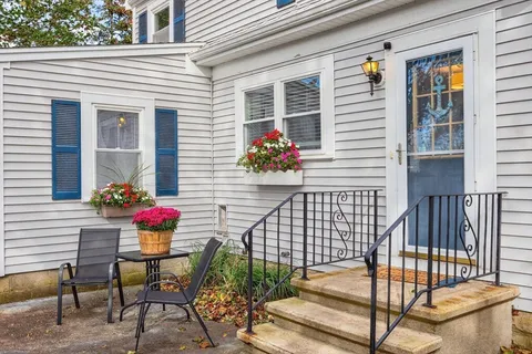 a view of a porch with a table and chairs and potted plants