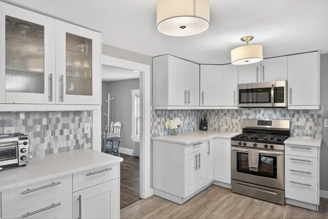 a kitchen with white cabinets and appliances