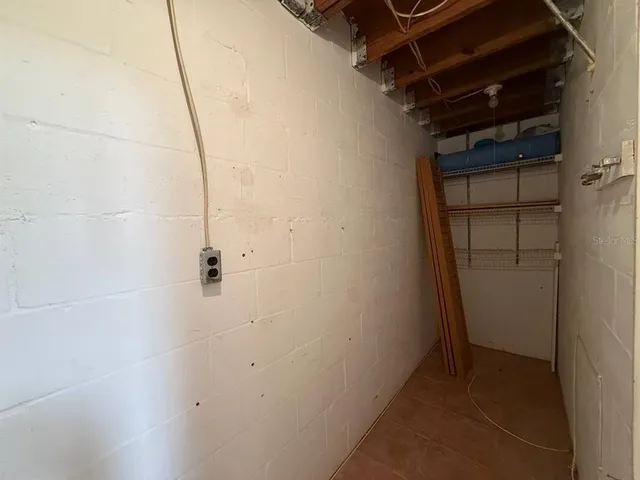 an empty room with a large window and chandelier