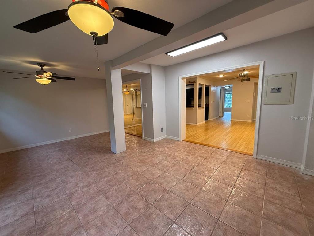 1217 McMullen Booth Road Clearwater, FL 33759 - Photo 12 of 44 an empty room with a large window and chandelier