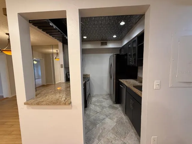 a kitchen with stainless steel appliances granite countertop a refrigerator and a stove