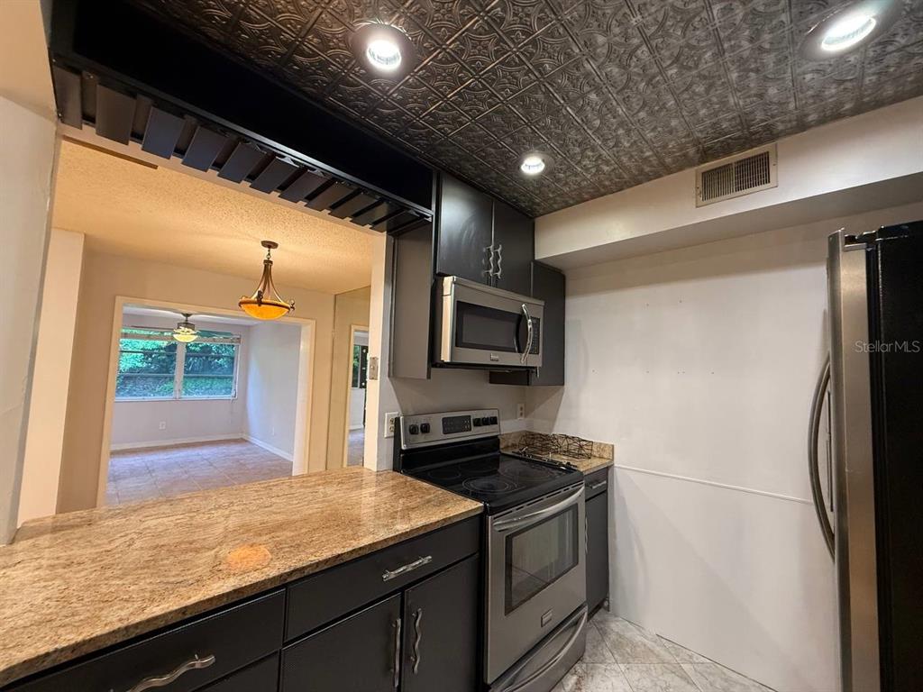 1217 McMullen Booth Road Clearwater, FL 33759 - Photo 21 of 44 a kitchen with stainless steel appliances granite countertop a sink and a refrigerator