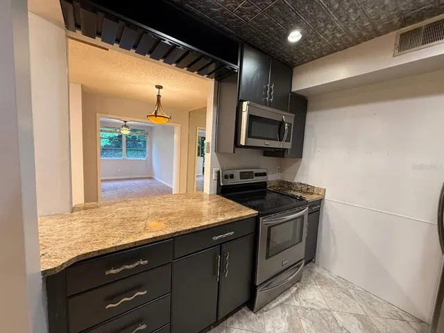 a kitchen with a sink refrigerator and microwave