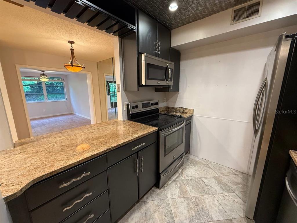 1217 McMullen Booth Road Clearwater, FL 33759 - Photo 23 of 44 a kitchen with a sink refrigerator and microwave