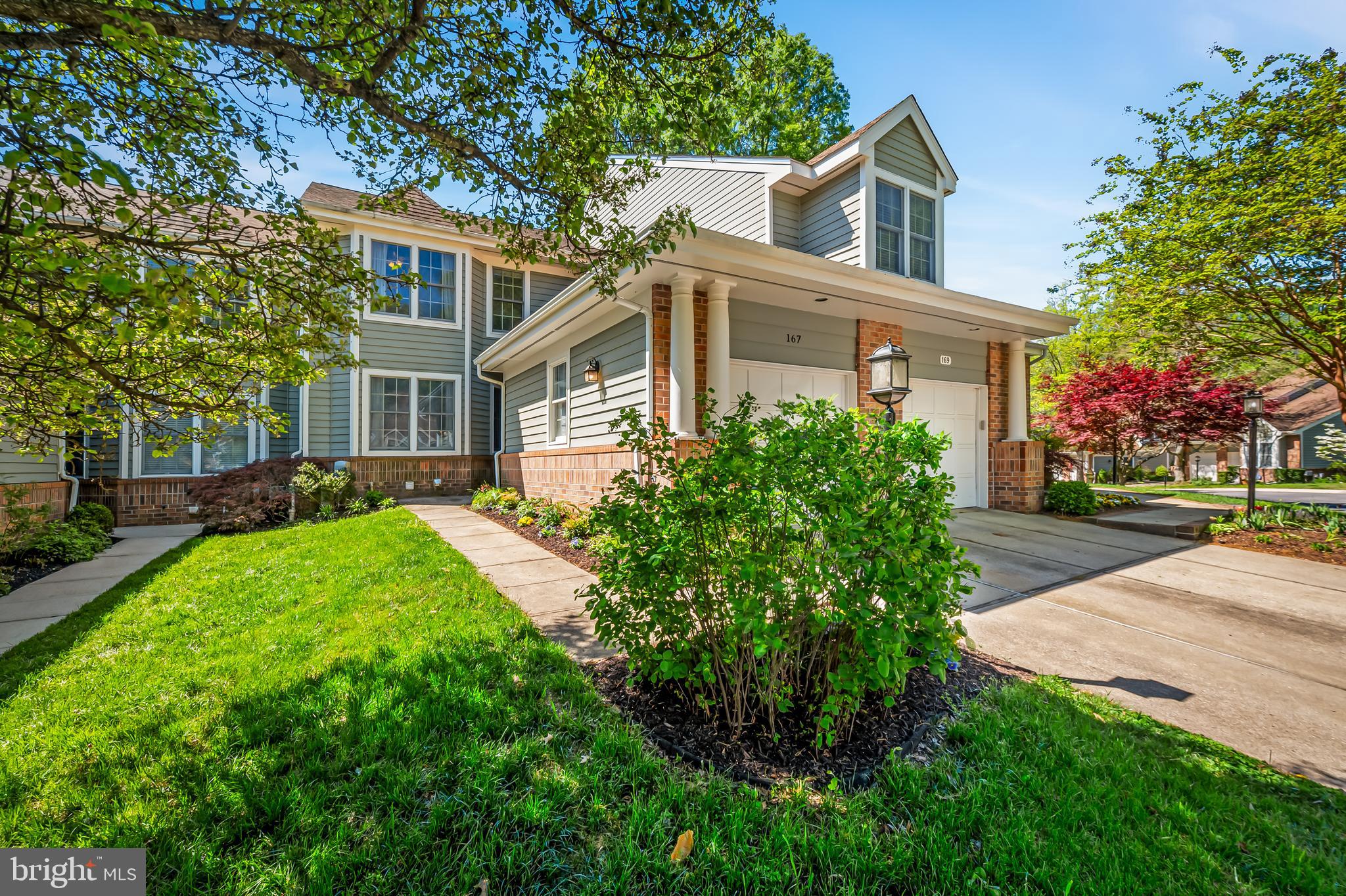 a front view of a house with a yard and trees