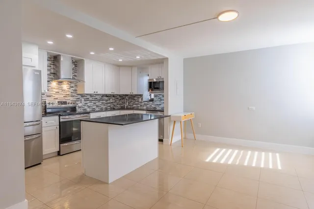 a kitchen with stainless steel appliances kitchen island granite countertop a sink and cabinets