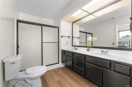 a bathroom with a double vanity sink and mirror with shower