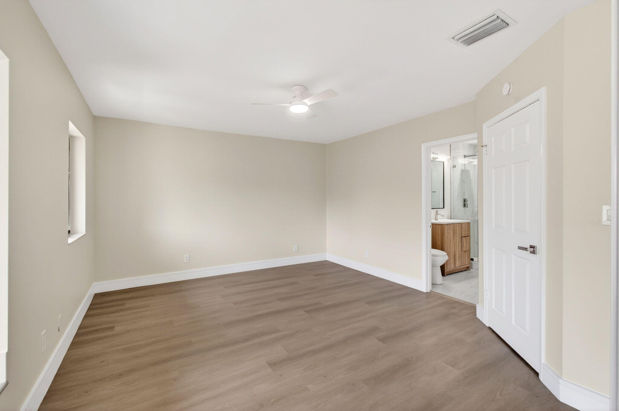 1330 Northwest 13th Street, Unit 12 Boca Raton, FL 33486 - Photo 35 of 52 an empty room with wooden floor and windows