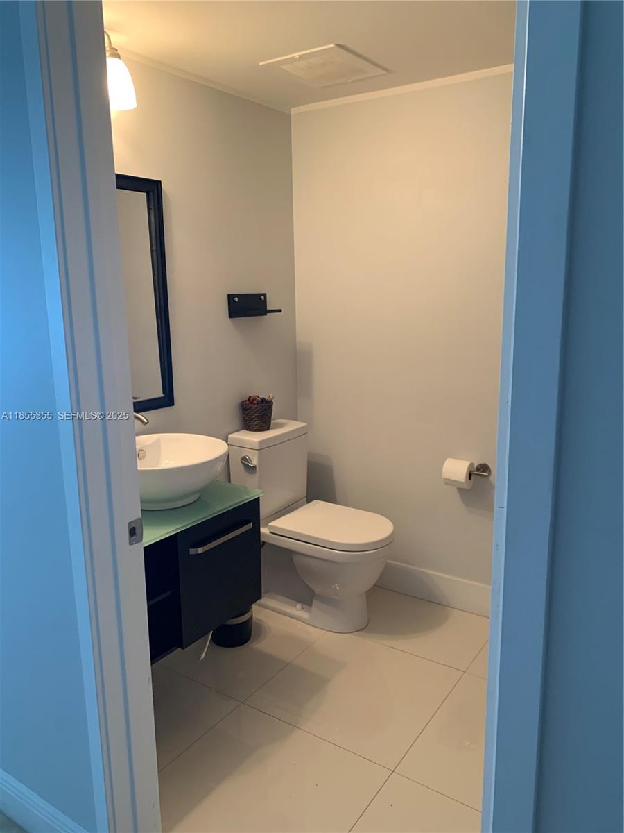 185 Southwest 7th Street, Unit 2202 Miami, FL 33130 - Photo 13 of 36 a bathroom with a toilet a sink and mirror