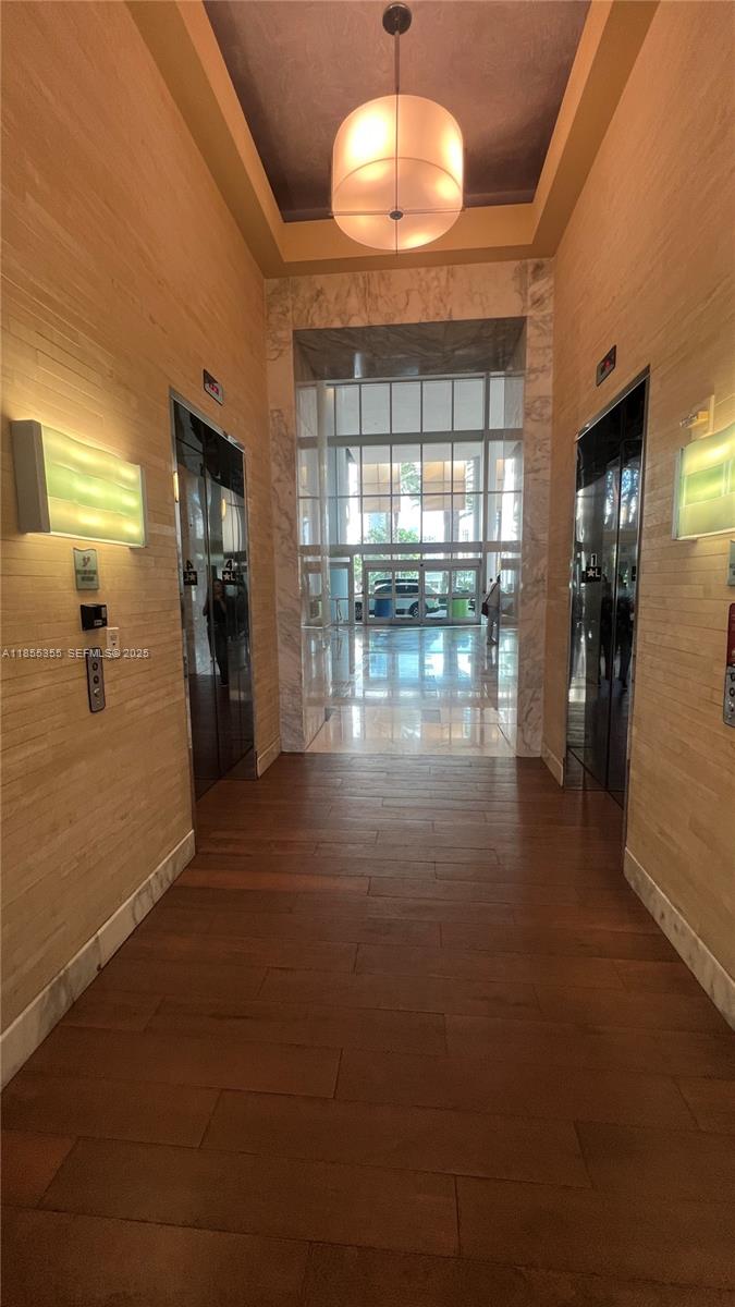 185 Southwest 7th Street, Unit 2202 Miami, FL 33130 - Photo 29 of 36 an empty room with wooden floor and chandelier