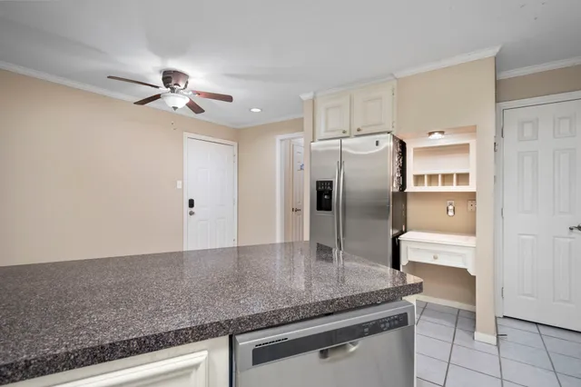 a kitchen with stainless steel appliances granite countertop a refrigerator a sink and white cabinets
