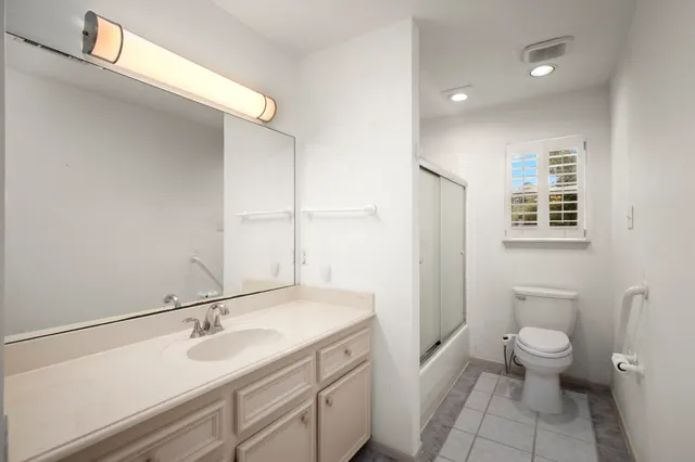a bathroom with a double vanity sink toilet and shower