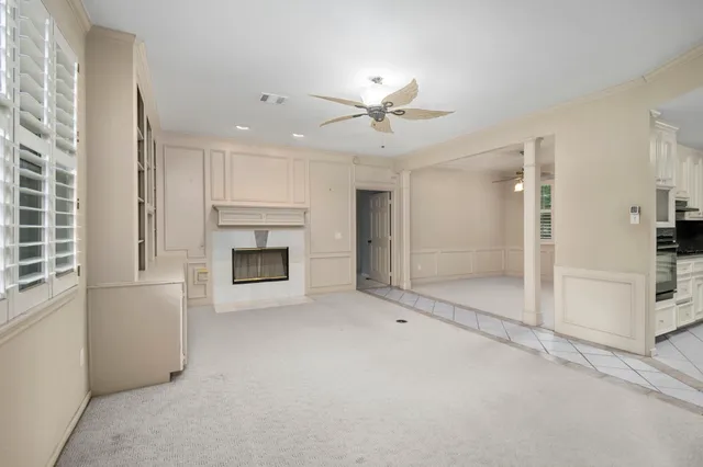 a view of an empty room with a fireplace and a window