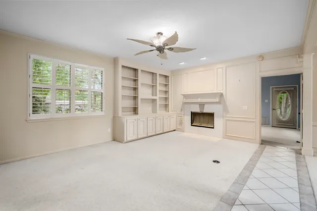 an empty room with windows and fireplace
