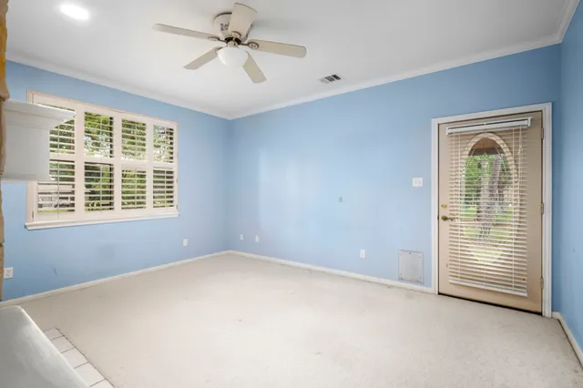 an empty room with windows and fan