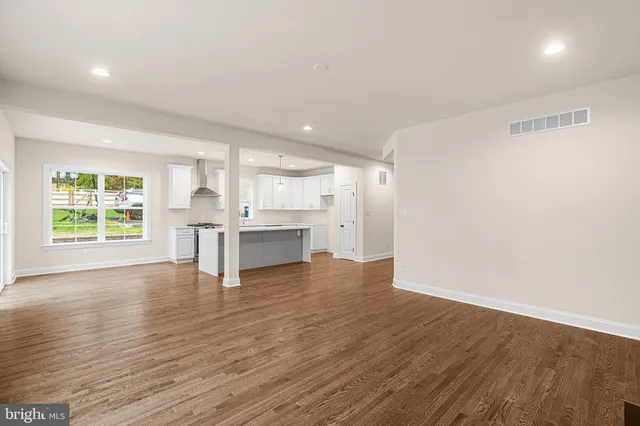 a kitchen with kitchen island a sink wooden floor and a window