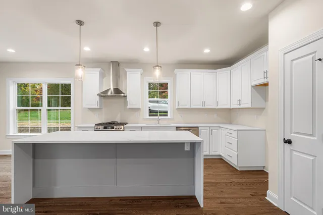 a kitchen with a sink stove and wooden floor