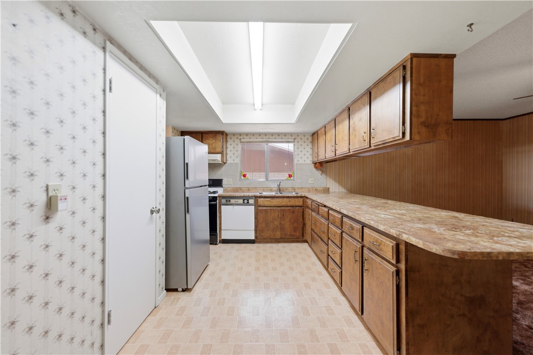 590 Ridgecrest Drive Kingman, AZ 86409 - Photo 14 of 33 a kitchen with stainless steel appliances granite countertop a stove a sink dishwasher and a refrigerator
