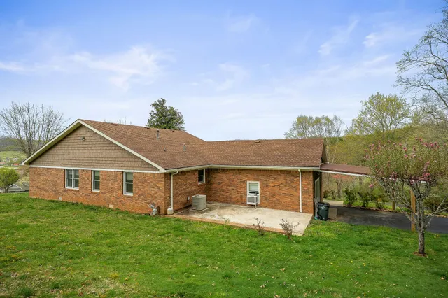 a view of a house with a yard and sitting area
