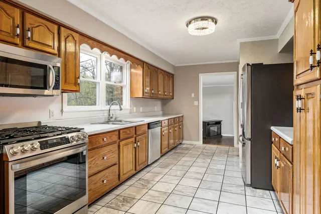 a kitchen with stainless steel appliances granite countertop a stove a sink and a refrigerator