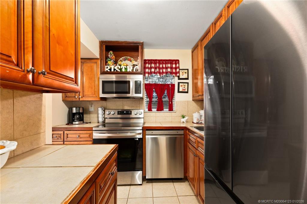 1980 Southwest Palm City Road, Unit 50J Stuart, FL 34994 - Photo 7 of 37 a kitchen with stainless steel appliances granite countertop a stove a sink and a microwave