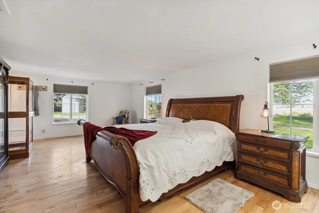 a bedroom with a bed and wooden floor
