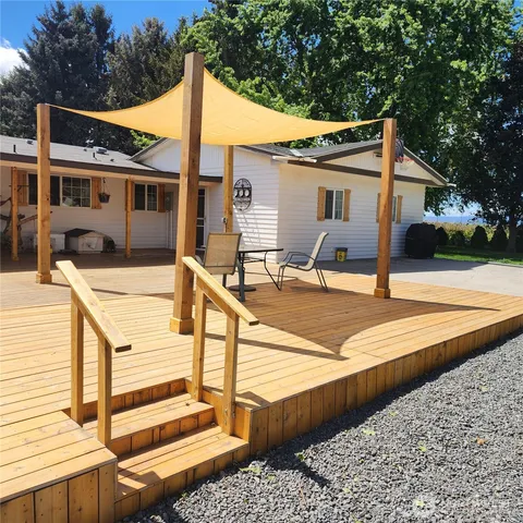a view of a house with pool and a wooden bench