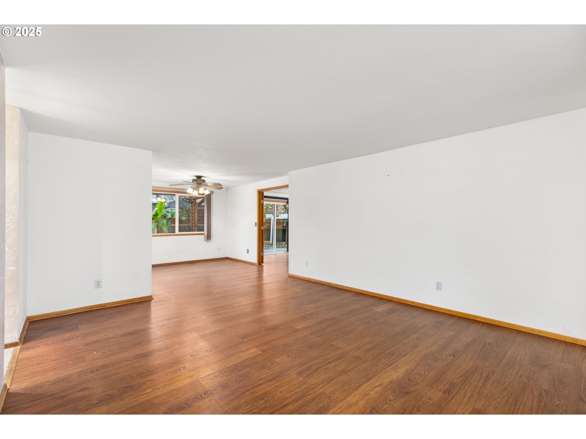 17130 Southwest Baker Street Beaverton, OR 97007 - Photo 12 of 37 a view of an empty room with wooden floor and a window