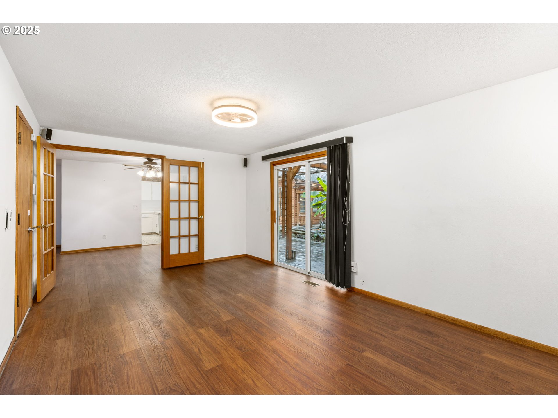 17130 Southwest Baker Street Beaverton, OR 97007 - Photo 17 of 37 a view of an empty room with a window and wooden floor