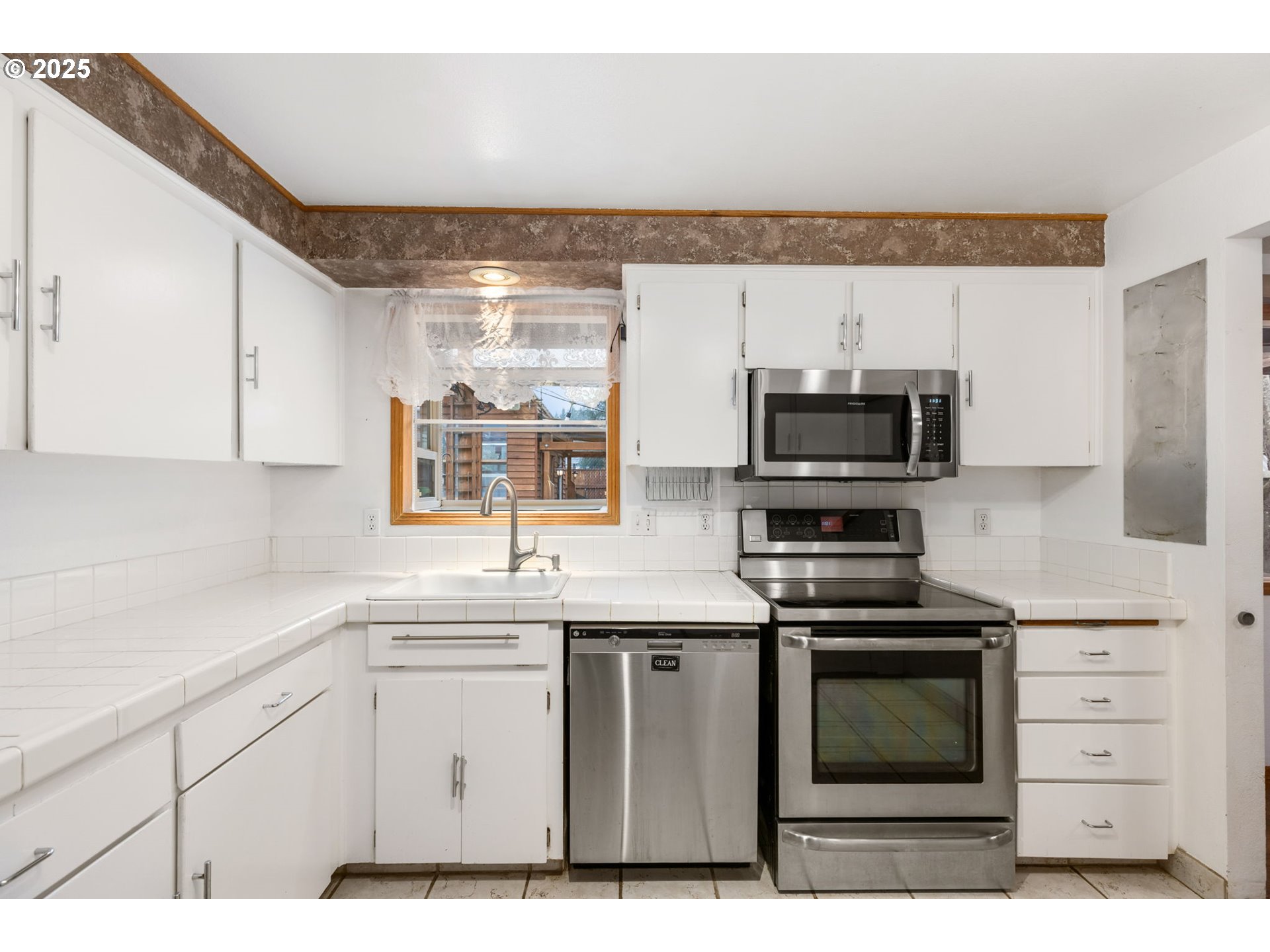 17130 Southwest Baker Street Beaverton, OR 97007 - Photo 18 of 37 a kitchen with stainless steel appliances a sink stove and microwave