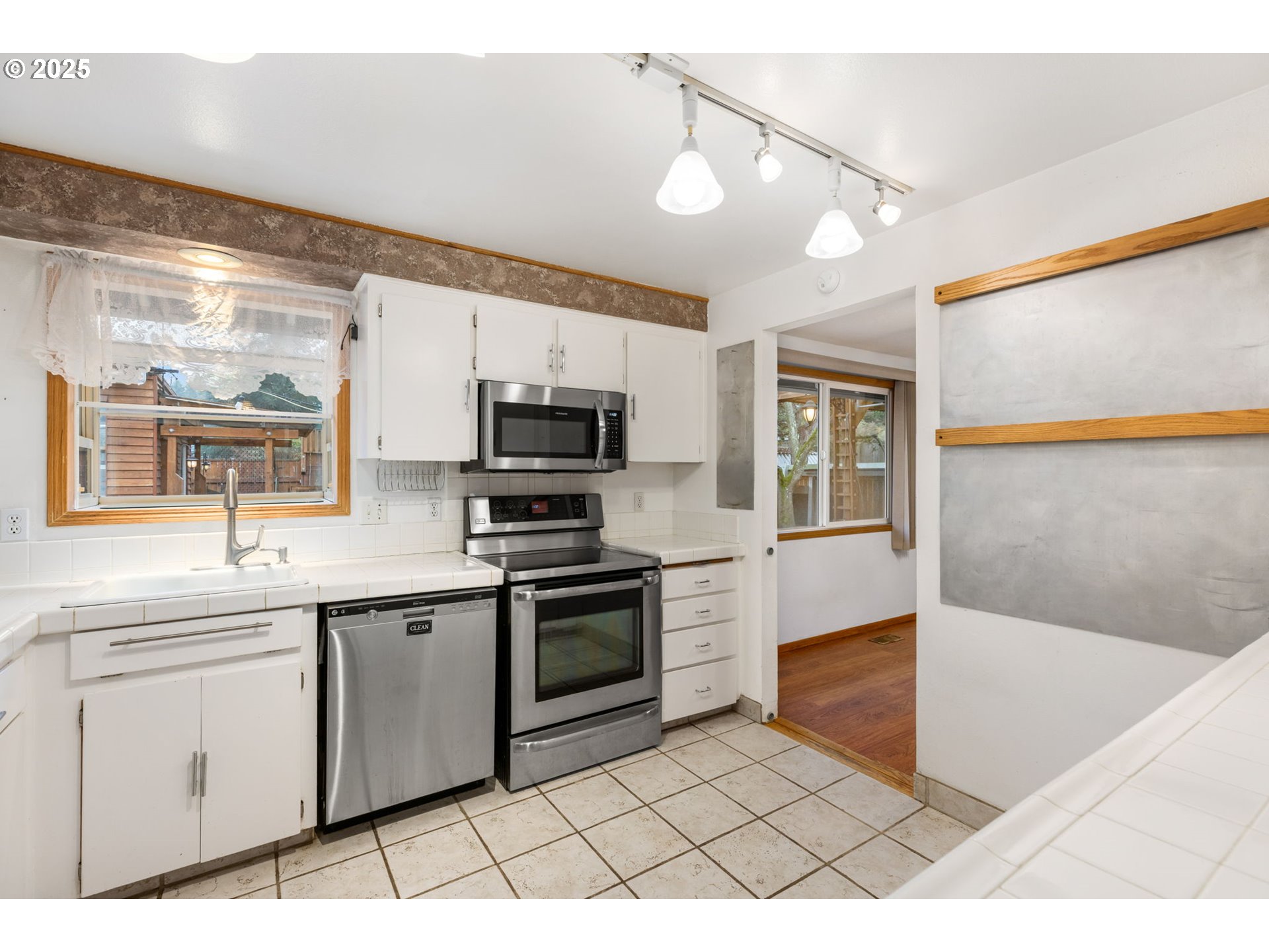 17130 Southwest Baker Street Beaverton, OR 97007 - Photo 19 of 37 a kitchen with stainless steel appliances kitchen island granite countertop a sink and cabinets